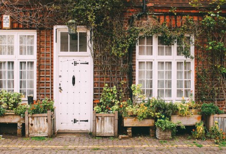 Cottage with white front door and planters outside
